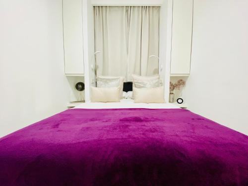 a bed with a purple blanket on top of it at Canaryislandshost l Brisa del Atlántico in Playa Honda