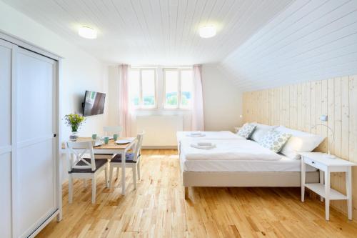 a living room with a bed and a table at Marvelous lake view apartments - Jezerka Lipno in Přední Výtoň