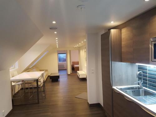 uma cozinha com um lavatório e uma mesa num quarto em Lagunen Apartments em Bergen