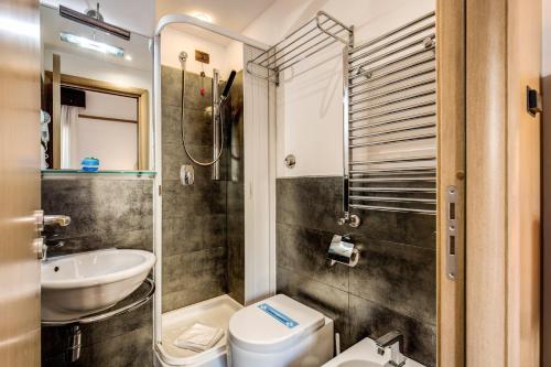małą łazienkę z toaletą i umywalką w obiekcie Ginevra Palace Hotel w Rzymie