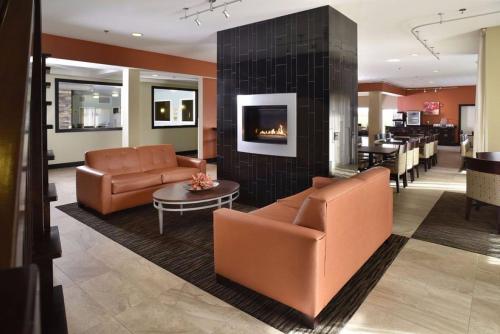 a lobby with two leather chairs and a fireplace at Berlin Grande Hotel in Berlin