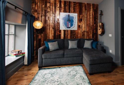 a living room with a couch and a wooden wall at BrewDog Kennels - Aberdeen in Aberdeen