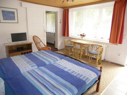 ヘリングスドルフにあるBungalow Heinzeのベッドルーム1室(ベッド1台、テーブル、椅子付)
