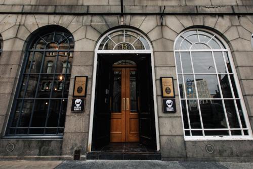a building with three windows and a wooden door at BrewDog Kennels - Aberdeen in Aberdeen