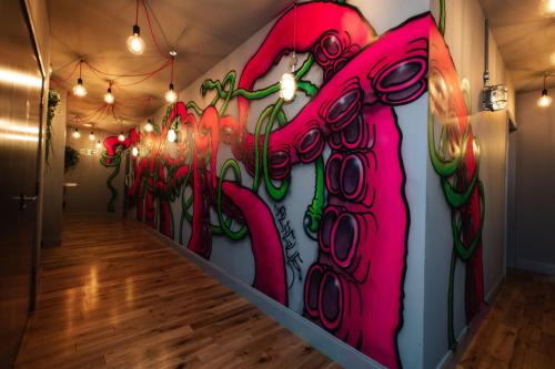 a hallway with a wall covered in graffiti at BrewDog Kennels - Aberdeen in Aberdeen