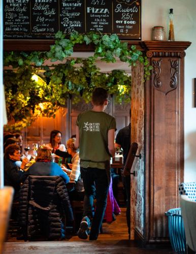 a man walking into a restaurant with a group of people at The Vineyard Lamberhurst in Lamberhurst