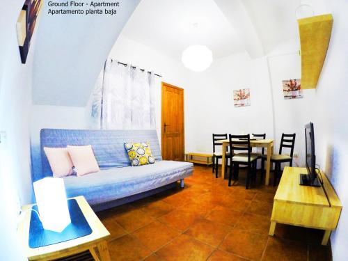 a living room with a blue couch and a table at Apartamentos Ester in Santa Cruz de Tenerife