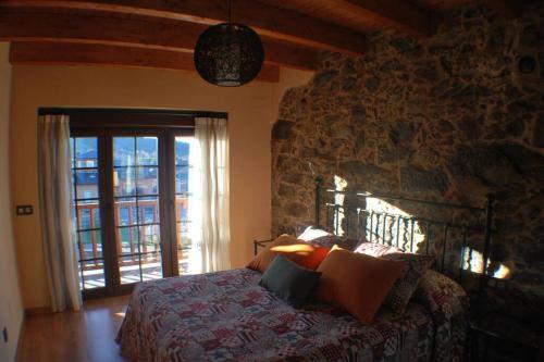 a bedroom with a bed and a stone wall at Las Maticas in Molinaseca