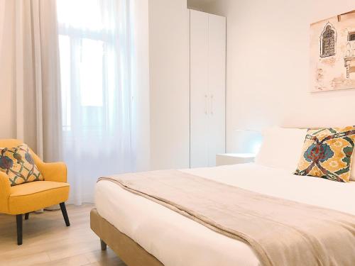 ein Schlafzimmer mit einem großen Bett und einem gelben Stuhl in der Unterkunft Leoncino Suite in Verona