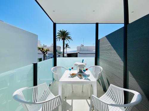a white table and chairs on a balcony at Canaryislandshost l Brisa del Atlántico in Playa Honda