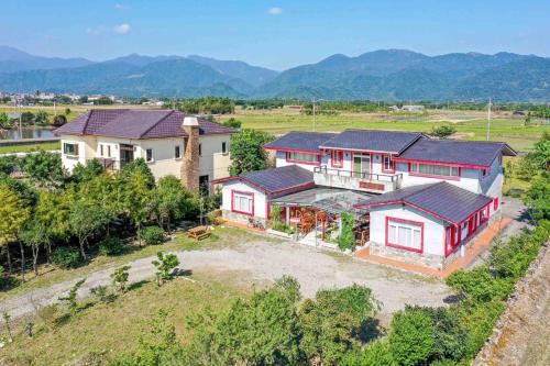 an aerial view of a house with mountains in the background at Farmland B&B in Guilin