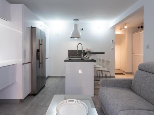 un salon avec un canapé et une cuisine dans l'établissement Les Mimosas bord de mer, des plages, du port et de toutes commodités, à Saint-Cyr-sur-Mer