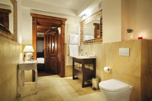 a bathroom with a toilet and a sink at Apartamenty Chleb i Wino Strumykowa in Toruń