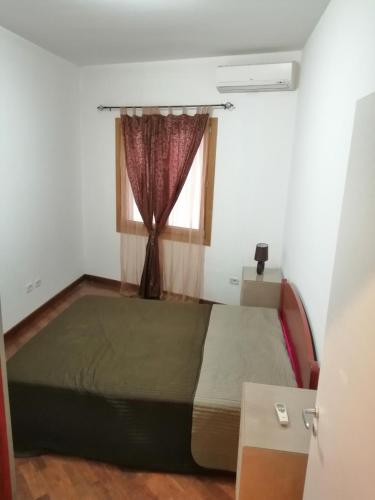 a bedroom with a bed and a window at Apartman Sadutas in Rafailovici