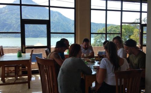 a group of people sitting at a table in a restaurant at Volcano Living in Kintamani