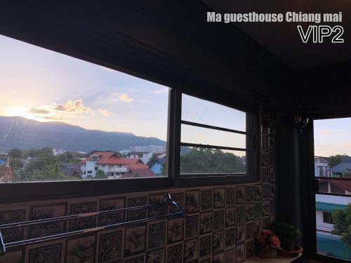 a room with windows with a view of a mountain at Ma Guesthouse Chiang Mai in Chiang Mai