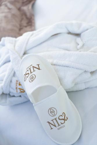 a pair of white flip flops sitting next to towels at Niss Lara Hotel in Antalya