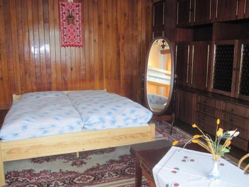 a bedroom with a bed and a mirror and a table at Vila Daniel in Liptovský Mikuláš