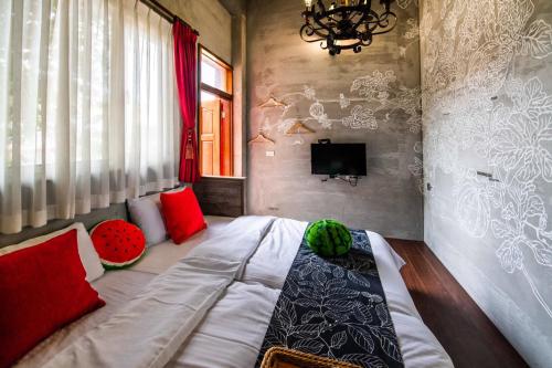 a bedroom with a bed with red pillows and a tv at Farmland B&B in Guilin