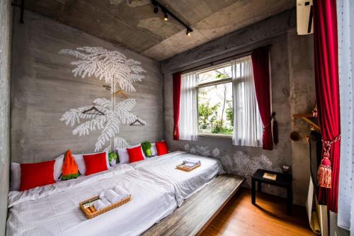 Schlafzimmer mit einem Bett mit roten und grünen Kissen in der Unterkunft Farmland B&B in Guilin