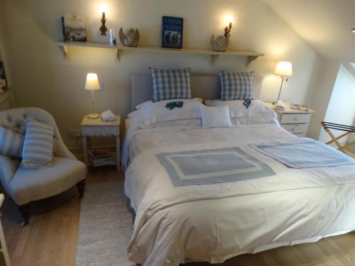 a bedroom with a large bed and a chair at Hurlingham Bed and Breakfast in London