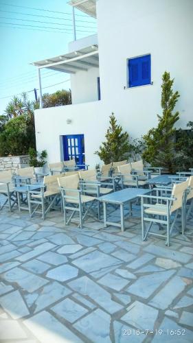 a group of tables and chairs on a patio at Nicos Studios & Apartments in Logaras