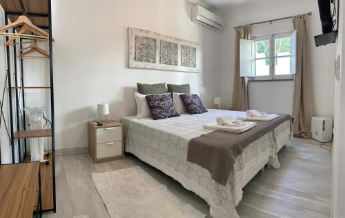 a bedroom with a large bed with blue pillows at Discovery Tavira in Tavira