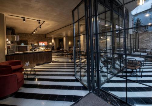 a lobby with glass walls and tables and chairs at Hotel Bosfora Plus in Istanbul