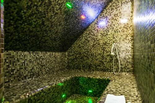 a bathroom with a tub with green lights at Steam Sauna Apartments in Gargždai
