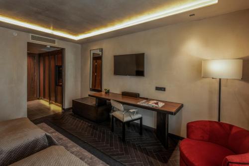 a hotel room with a desk and a red chair at Hotel Bosfora Plus in Istanbul