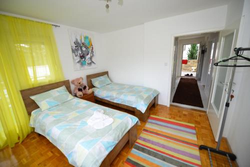 a room with two beds and a rug at Apartment Mirela in Sarajevo