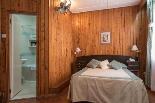 een slaapkamer met een bed en een badkamer met een bad bij The Oakwood Hotel in Nairobi