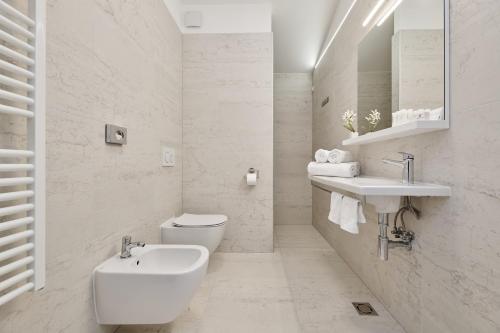 a white bathroom with a sink and a toilet at B&B Artegnana 1798 in Grožnjan