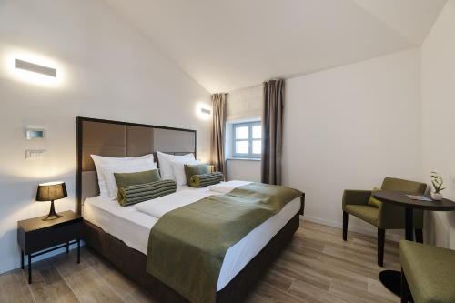 a hotel room with a large bed and a chair at B&B Artegnana 1798 in Grožnjan