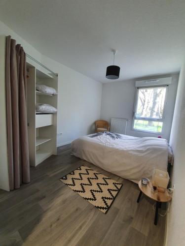 1 dormitorio con 1 cama con alfombra y ventana en L'accalmie Audenge en Audenge