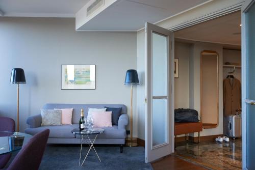 a living room with a blue couch and a table at Original Sokos Hotel Vaakuna Helsinki in Helsinki