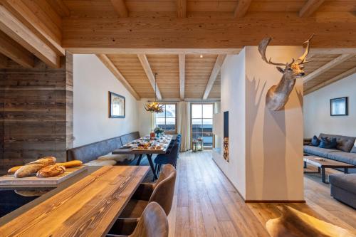 a dining room with a table and a deer head on the wall at Brunnenhof Luxury Apartments in Lech am Arlberg
