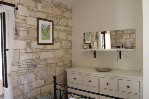 una camera con un muro in pietra e un comò di Haven a Limassol