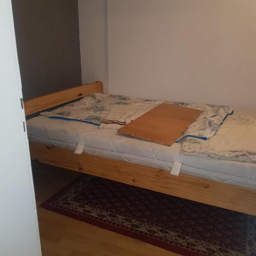 1 cama con marco de madera en una habitación en Ferienwohnung Wettin am Petersbrunnen, en Wettin