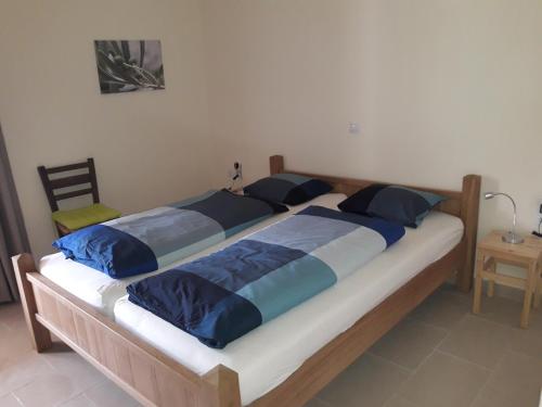 2 camas con almohadas azules en un dormitorio en Villa Dianthe, en Myrtos