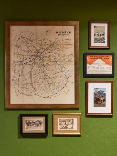 a wall with framed maps on a green wall at Chalet Alpen Valley, Mont-Blanc in Combloux