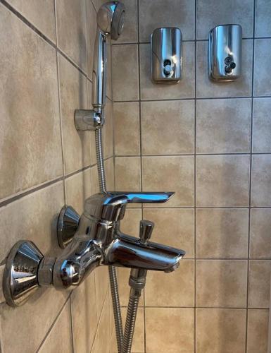 a shower with a faucet on a tiled wall at Casa Del Mare (South Evia) in Nea Stira