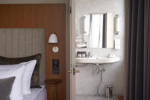 ein Schlafzimmer mit einem Waschbecken und einem Spiegel an der Wand in der Unterkunft Original Sokos Hotel Vaakuna Helsinki in Helsinki