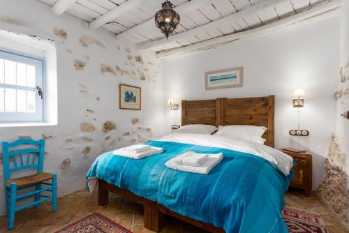 a bedroom with a blue bed and a blue chair at Casa Higueras in Moclín