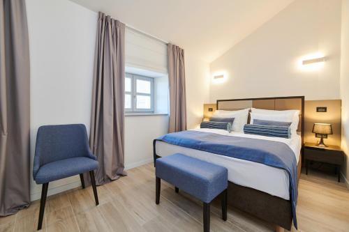 1 dormitorio con 1 cama y 1 silla azul en B&B Artegnana 1798 en Grožnjan