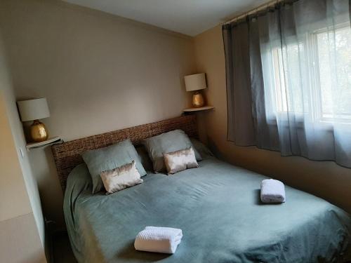 a bedroom with a bed with two towels on it at Gîte de charme in Arles