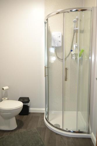 a shower stall in a bathroom with a toilet at Harbour View Apartment Wick in Wick