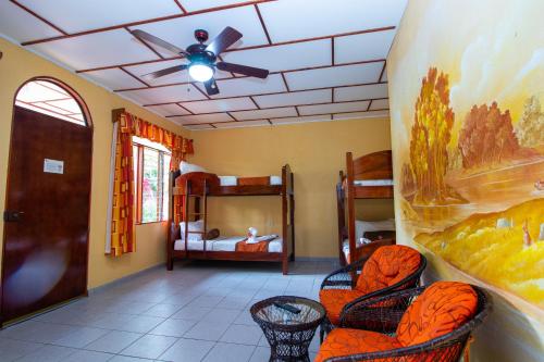 a room with three bunk beds and a ceiling fan at Hotel La Rosa de America in Alajuela City