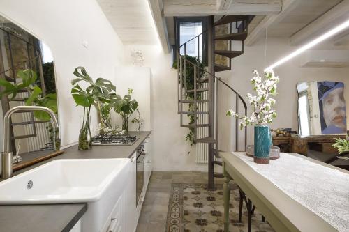 a kitchen with a sink and a spiral staircase at Nicotera Apartment in Noto
