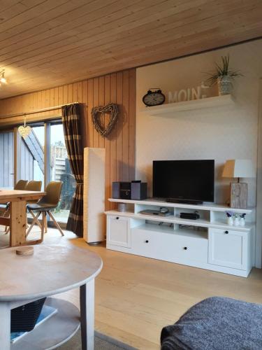een woonkamer met een televisie op een wit entertainmentcentrum bij Fräulein Emma Lotta in Kronsgaard